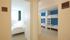 a room with two bunk beds and a mirror at Alte Metzg - Hostel in Appenzell