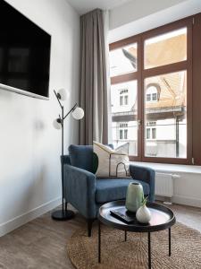 uma sala de estar com um sofá azul e uma grande janela em limehome Leipzig Am Brühl em Leipzig