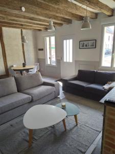ein Wohnzimmer mit zwei Sofas und einem Tisch in der Unterkunft Gite Bildstein in Coullons