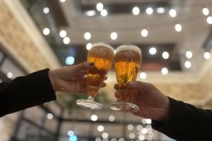 two people holding glasses of beer in their hands at ZONK HOTEL Hakata in Fukuoka