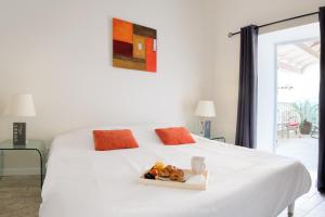 a white bed with a tray of food on it at La Virginie - Suite Parée'Ô in La Couarde-sur-Mer
