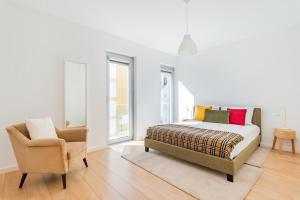 - une chambre avec un lit et une chaise dans l'établissement Oeiras Elegant Retreat with Pool, à Oeiras