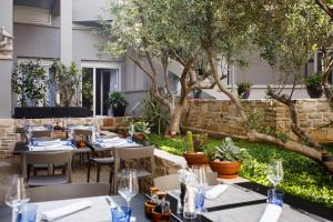 a restaurant with tables and chairs and trees at Hotel Osam - Adults Only in Supetar