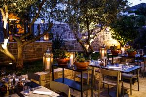 a restaurant with tables and chairs with candles and lights at Hotel Osam - Adults Only in Supetar