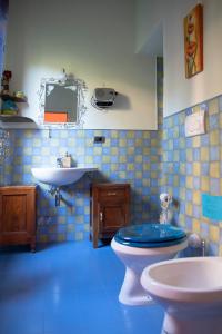 a blue tiled bathroom with a toilet and a sink at il mare di nonna Vi in Lerici