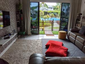 a living room with a couch and red pillows on the floor at Resort-styled Stay - No Pool, select 2 OR 3 bedrooms in Cyberjaya