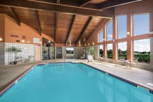a swimming pool in a house with windows at AmericInn by Wyndham Cedar Falls in Cedar Falls
