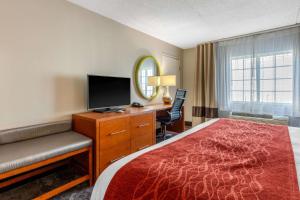 a hotel room with a bed and a desk with a television at Comfort Inn & Suites Nashville-Antioch in Antioch