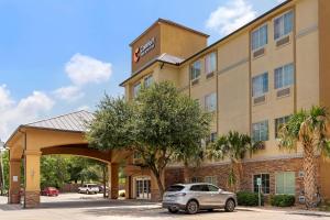 a hotel with a car parked in front of it at Comfort Inn & Suites Near Six Flags & Medical Center in San Antonio