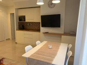 eine Küche mit einem Tisch mit Stühlen und einem TV in der Unterkunft Villa Apartment (Box Privato) in Foggia