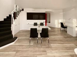 a living room with a table and chairs and a staircase at DORMERO Hotel Düsseldorf in Düsseldorf