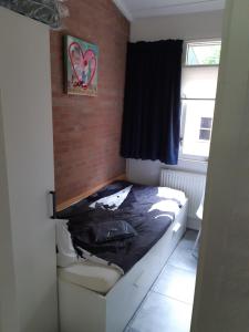 ビッディングハイゼンにあるVakantiehuis Veluwemeer House 40の小さなベッドルーム(黒いシーツ付きのベッド付) +33枚の写真