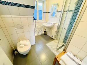 ein Bad mit einem WC, einem Waschbecken und einer Dusche in der Unterkunft Appartement christ-sylt in Westerland