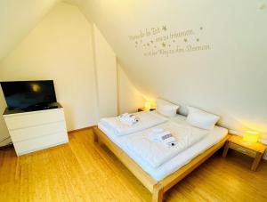 ein kleines Schlafzimmer mit einem Bett und einem TV in der Unterkunft Appartement christ-sylt in Westerland