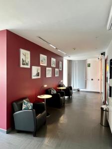 salon z krzesłami i czerwoną ścianą w obiekcie Hostal Apolo w Barcelonie