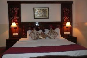 a bedroom with a large bed with pillows on it at Hotel New Empire in New Delhi