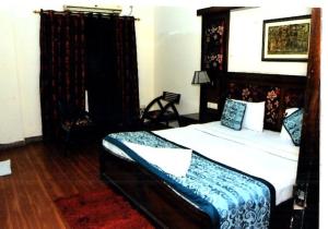 a bedroom with a bed with a wooden headboard at Hotel New Empire in New Delhi