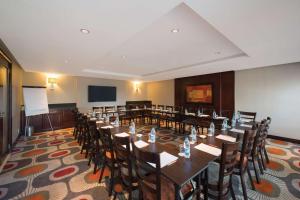 a conference room with tables and chairs and a podium at The RidgePoint Hotel in Witbank