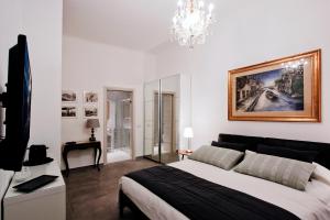 um quarto com uma cama grande e um lustre em IMHOME - Porta Romana em Milão