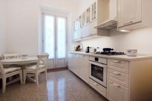 a white kitchen with a table and a stove top oven at IMHOME - Porta Romana in Milan