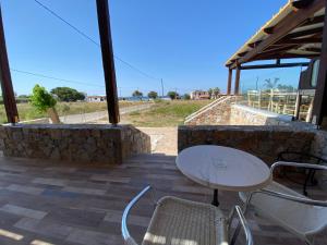 a table and chairs on a patio with a stone wall at Blue Sky in Frangokastello
