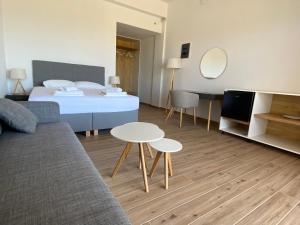 a bedroom with a bed and a table and a couch at Blue Sky in Frangokastello