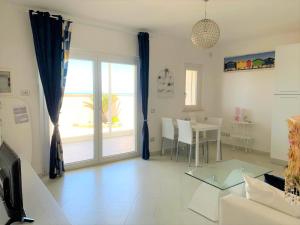 a living room with a couch and a glass table at Alex's House Focene in Fiumicino