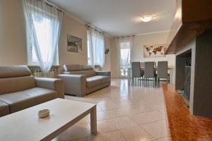 a living room with a couch and a table at Exclusive Villa le Palme in Polpenazze del Garda