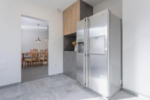 a stainless steel refrigerator in a kitchen with a dining room at Villa Lhota in Lhota