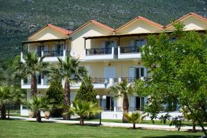 ein Gebäude mit Palmen davor in der Unterkunft Byzantio in Parga