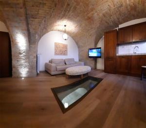 sala de estar con sofá y TV en Dimora Porta Venere en Spello