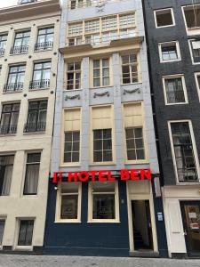 un bâtiment d'hôtel avec un panneau d'hôtel devant lui dans l'établissement Budget Hotel Ben, à Amsterdam