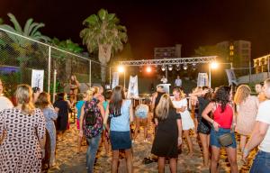 a crowd of people standing on the beach at night at Holiday Park Resort - Ultra All İnclusive in Okurcalar +118 photos