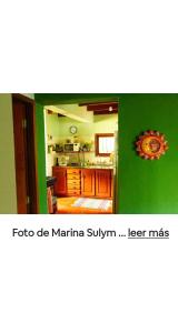 a kitchen with a green wall and a kitchen with at Jardín de Naipí 3 in Puerto Iguazú