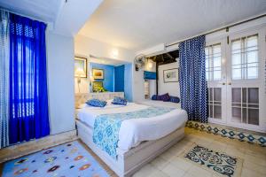een slaapkamer met blauwe muren en een bed met blauwe gordijnen bij Neemrana Fort-Palace in Neemrana