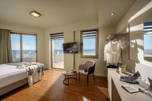 a hotel room with a bed and a desk with a dresser at Marin Hotel in Heraklio Town