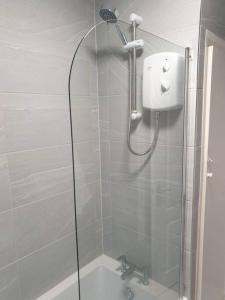 a shower with a glass door next to a sink at Chester Le Street Amythyst 3 Bedroom House in Chester-le-Street