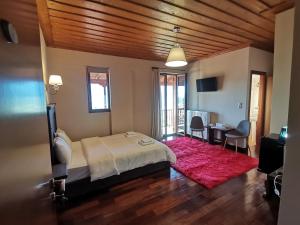 a bedroom with a bed and a table and chairs at Panorama Vytinas in Vitina