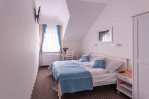 ein Schlafzimmer mit einem Bett mit einer blauen Decke darauf in der Unterkunft Gościniec Kasztel u Gostla in Murowana Goslin