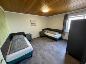 um pequeno quarto com 2 camas e uma janela em LD Apartments & Ferienwohnungen em Hanôver