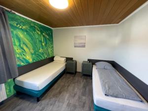 een kamer met 2 bedden en een schilderij aan de muur bij LD Apartments & Ferienwohnungen in Hannover