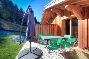 une terrasse avec un parasol, une table et des chaises dans l'établissement IMMOBILIER DE MONTAGNE - LA COLLECTION - CHAMPETRE, à Saint-Gervais-les-Bains