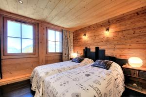 - 2 lits dans une chambre dotée de murs en bois et de fenêtres dans l'établissement IMMOBILIER DE MONTAGNE - LA COLLECTION - CHAMPETRE, à Saint-Gervais-les-Bains
