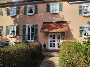 ein Haus mit rotem Dach und grünen Rollläden in der Unterkunft Landhotel Hirsch in Tübingen