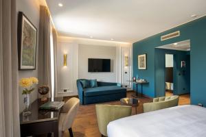 um quarto de hotel com uma cama e um sofá azul em Hotel Niccolo' V - Terme dei Papi em Viterbo