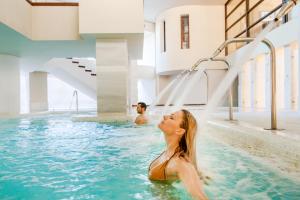 a man and a woman in the water in a swimming pool at Royal Hideaway Sancti Petri in Chiclana de la Frontera