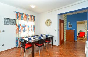 a dining room with a table and red chairs at Apartment Puzar 295 in Štinjan
