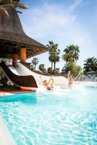 three children playing on a water slide at a resort at Royal Hideaway Sancti Petri in Chiclana de la Frontera