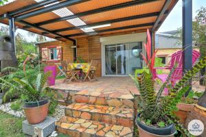 a patio with potted plants and a pergola at Les Gites Le Bambou - 3 étoiles - Les Avirons in Les Avirons