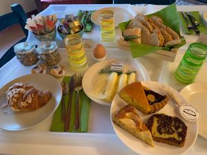 a table topped with plates of bread and pastries at Naturaverde Country House in Senigallia